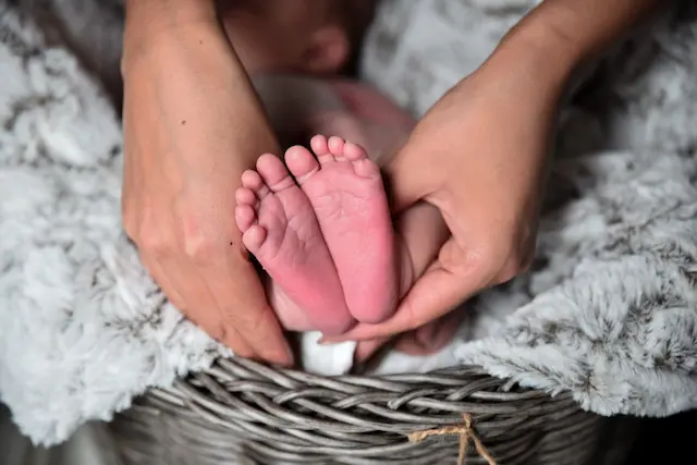 Mutter vergleicht die Füße ihres Babys