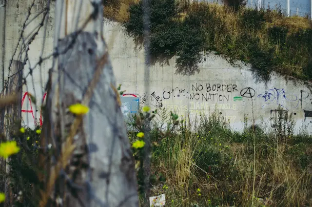 Grenzmauer mit Graffitti, die NO BORDER sagt.