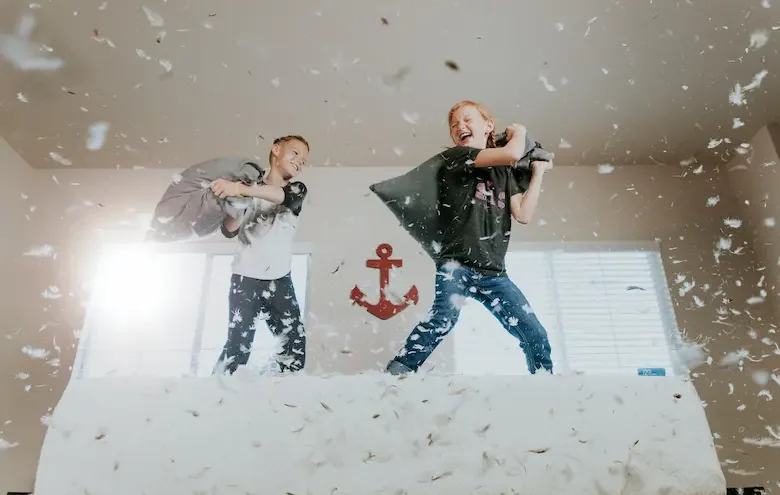 zwei Jugendliche haben eine Kissenschlacht