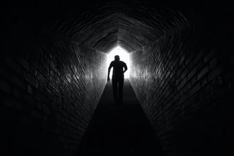 Mann läuft auf das Ende eines Tunnels zu